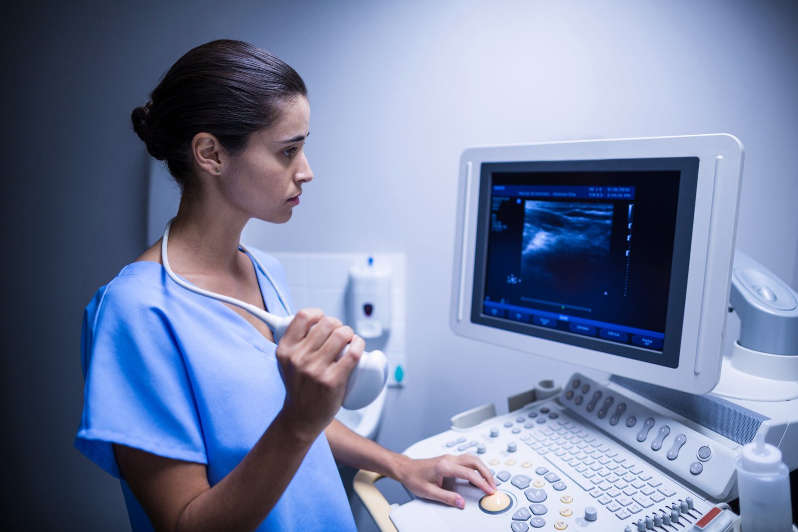 Doctor performing ultrasound scan using advanced sonography machine for pregnancy or gynecological checkup