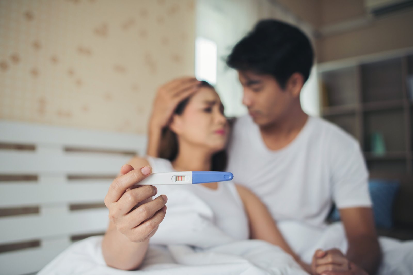 Couple holding pregnancy test discussing fertility evaluation and reproductive health