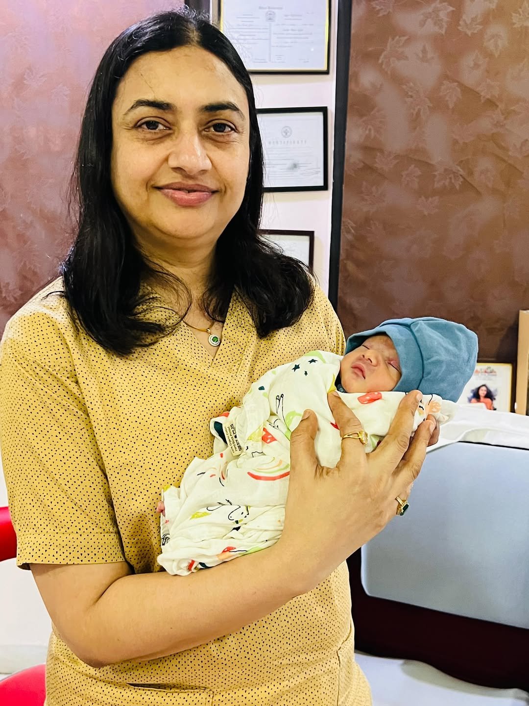 Dr Versha Jain holding a newborn baby after successful delivery at gynecology clinic